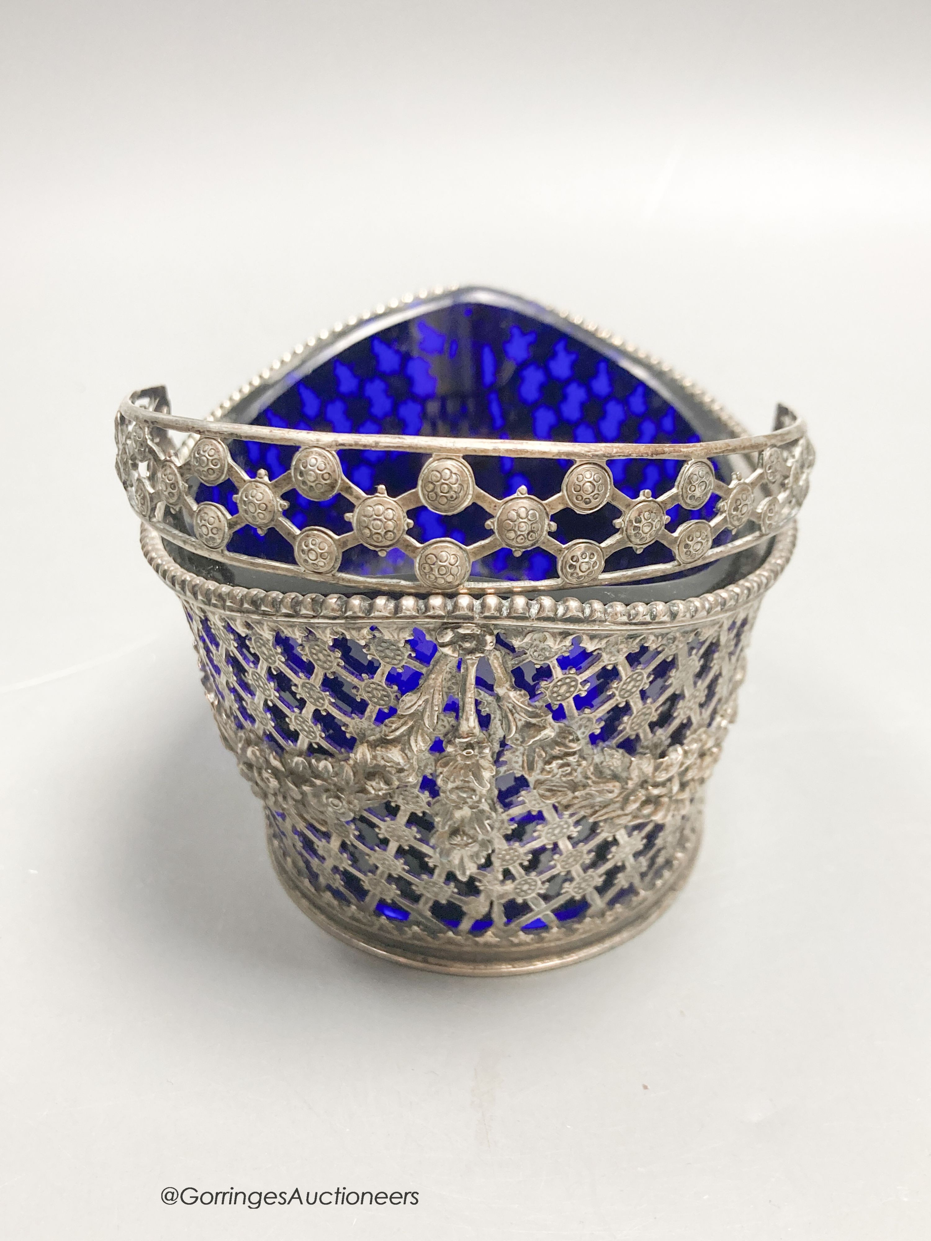A 19th century Dutch pierced white metal boat shaped sugar basket, with blue glass liner, length 11.5cm